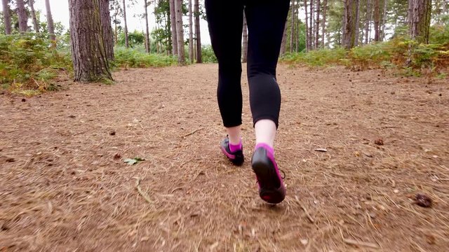 Girl jogging in the woods in slow motion