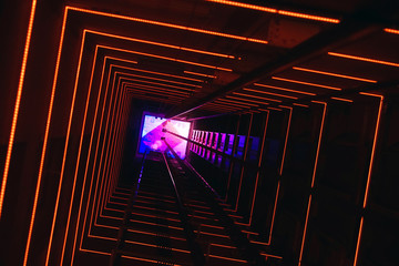  Elevator corridor in the building lit by red elumination. Futuristic elevator shaft is located in a high tower. Lift shaft in a residential building. Abstract, background. Bottom view.        © polack