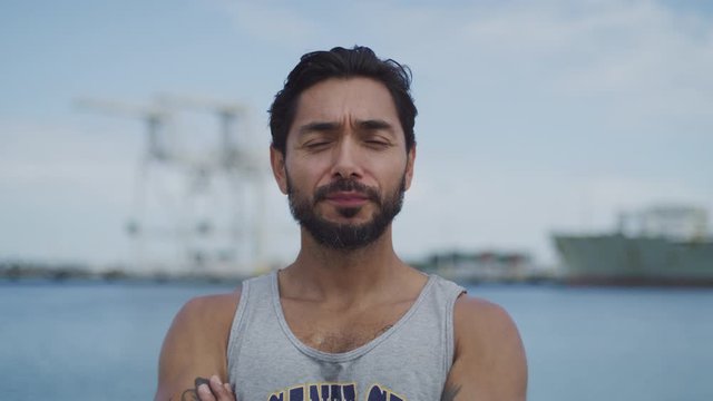 Latino Male on the beach smiling at the Camera Crossing his arms slow motion