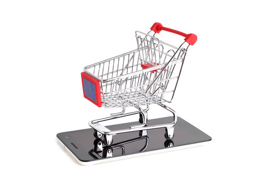 Supermarket trolley and smartphone on white background