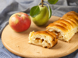 Cut apple pie with fruit lies on the table