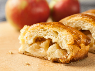 Two slices of apple pie on a wooden board
