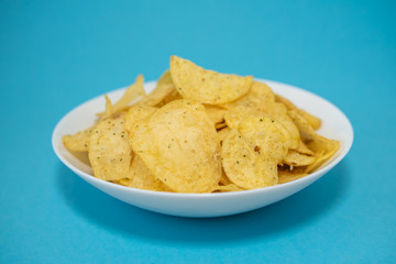 chips in white plate on blue background