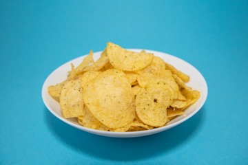 chips in white plate on blue background