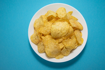 chips in white plate on blue background