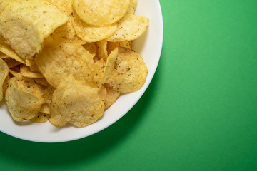 chips in white plate on green background