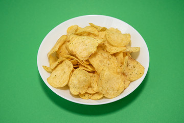 chips in white plate on green background