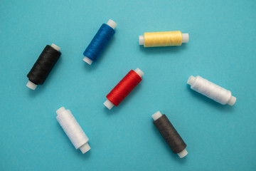 Set of sewing threads beautiful color (blue,yellow, green, white, black) on blue background