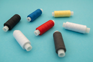Set of sewing threads beautiful color (blue,yellow, green, white, black) on blue background