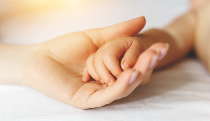 Mom holds gently the handle of her baby.