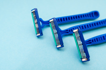 New disposable razor blade, on blue background, isolated