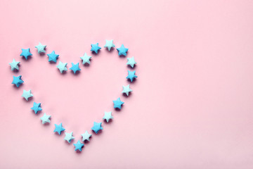 Paper stars in shape of heart on pink background
