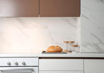 White kitchen interior. On a countertop lies a loaf of bread. Minimalism