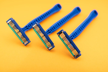 New disposable razor blade, on yellow background, isolated