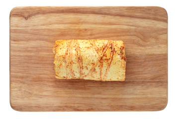 Cheese on a wooden board. Cheese with spices close-up on a white background. Top view.