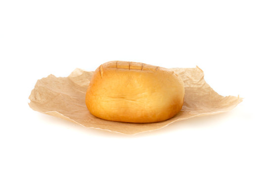 Cheese on parchment paper. Smoked cheese close-up on a white background.