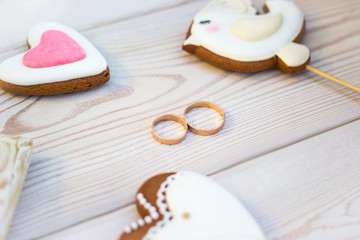 Fototapeta na wymiar Close up view on heart shaped cookies bisquits on stick and wedding rings.
