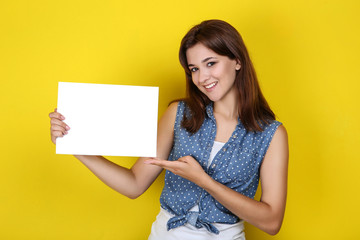 Fototapeta na wymiar Young woman with blank sheet of paper on yellow background