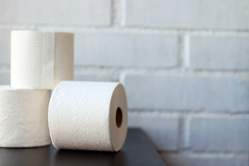 White toilet paper rolls and other home related objects against a white wall. Copy space.