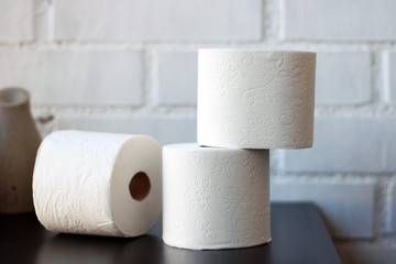 White toilet paper rolls and other home related objects against a white wall. Copy space.