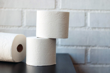 White toilet paper rolls and other home related objects against a white wall. Copy space.
