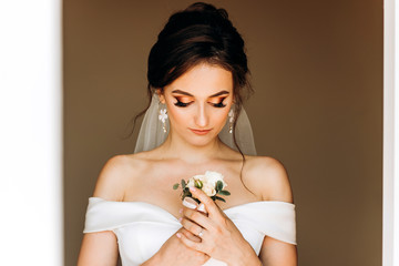 Luxury bride holding boutonniere in her hands