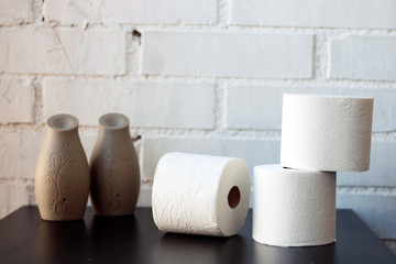 White toilet paper rolls and other home related objects against a white wall. Copy space.