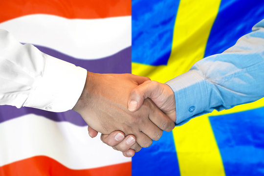 Business handshake on the background of two flags. Men handshake on the background of the Thailand and Sweden flag. Support concept