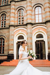 Charming bride standing near old building