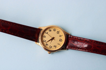 Gold and quartz watch on a blue background.