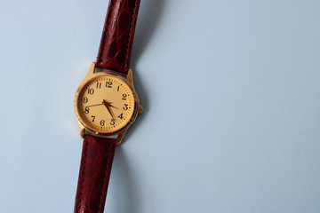 Gold and quartz watch on a blue background.