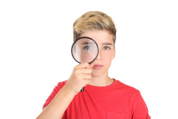 Young boy with magnifying glass on white background