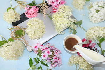 Computer, flowers and a cup of coffee on the desktop, top view, flat lay. Break at work in the office in comfortable conditions, the comfort of our home