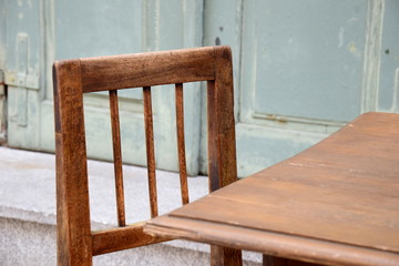 Alter Holzstuhl mit Holztisch vor einem alten renovierten Gasthof