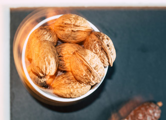 white bucket full of nuts on black background