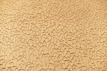 A fragment of the relief of a plastered wall. With light and shadows in light beige details, drops.