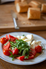 Cherry tomatoes with rucola leaves and pieces of mozarella cheese
