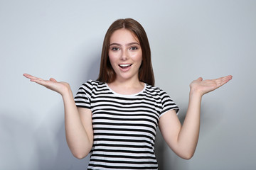 Young woman in striped t-shirt on grey background