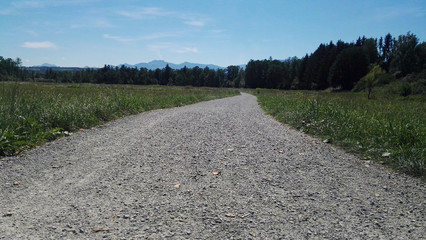 einsame strasse schotter bei strahlendem Sonnenschein