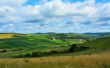 Fototapeta na wymiar rural landscape with a village between hills in Transylvania - Romania