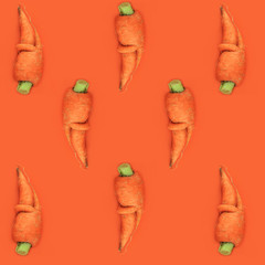 Carrot pattern on orange background, top view. Vegetables raw, vegan, ugly food concept, flatlay.