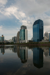 Fototapeta na wymiar Skyline of Bangkok with Water or Lake in the foreground and big Clouds in the Sky