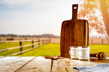 Table background with milk in glass.  Farm background in sunny autumn time.  Space for products, decoration or text.