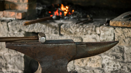 The hammer lies on the anvil in an old forge. Ancient crafts