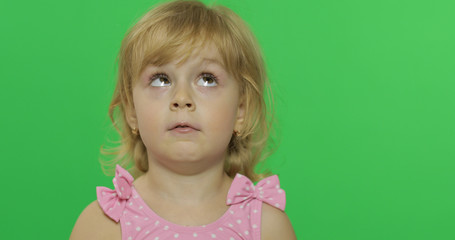 Pretty child in pink swimsuit looking uphill. Portrait close up. Chroma Key