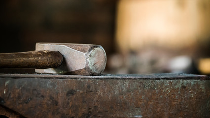 Close-up shot of hammer lies on the anvil, close-up with a blurred background