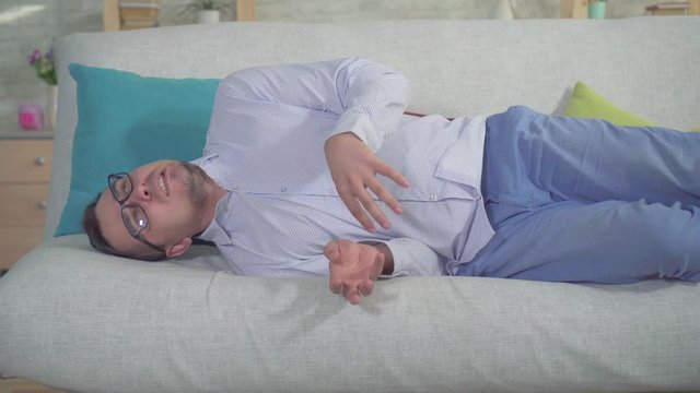 man with a smartphone had an epileptic seizure at home on the couch close up