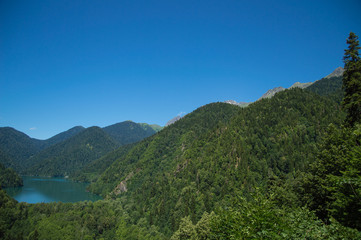 Naklejka na ściany i meble Panoramic view on mountain lake in front of mountain range.