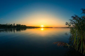 Fototapeta na wymiar Colorful sunset behind a calm lake