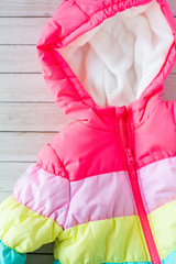 rainbow toddlers puffer jacket, wooden background